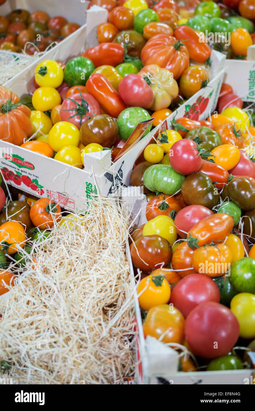 Fresh Heritage tomatoes in rustic crates on a market stall at London's Borough Market Stock Photo