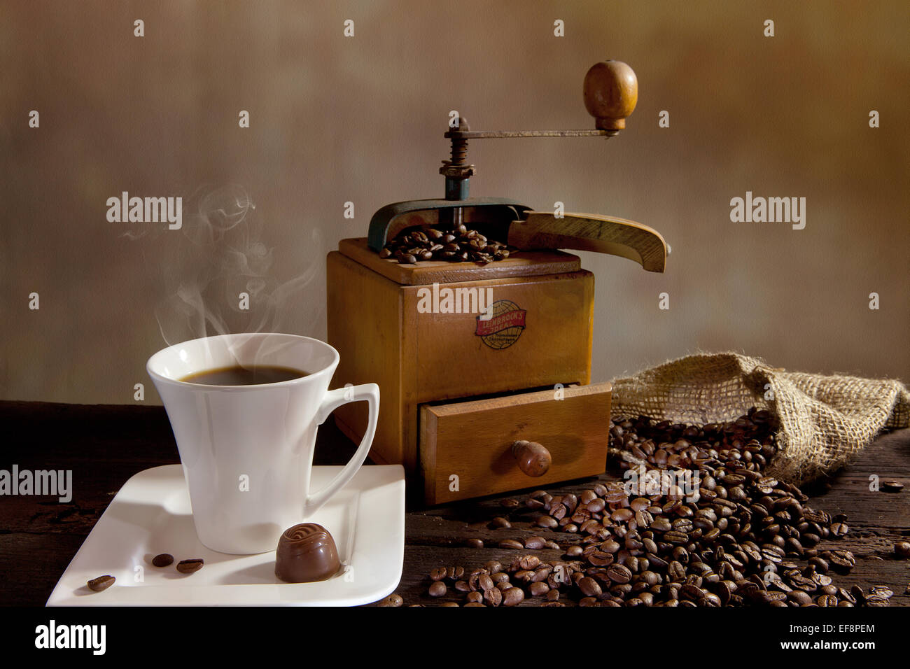 Cup of hot coffee, coffee grinder and coffee beans Stock Photo