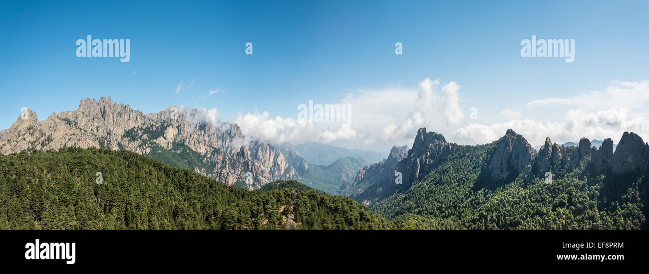 Panoramic view over a valley, mountain slopes with rocky peaks surrounded by pine forests, cliffs, Col de Bavella Stock Photo