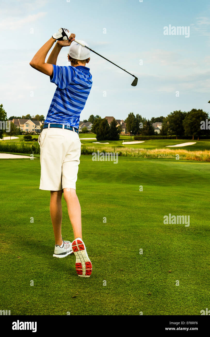 Rear view of teenage boy  playing golf Stock Photo