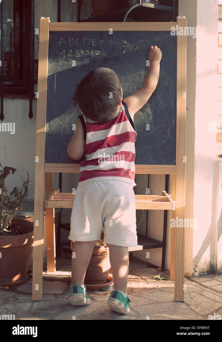 Boy writing on blackboard Stock Photo