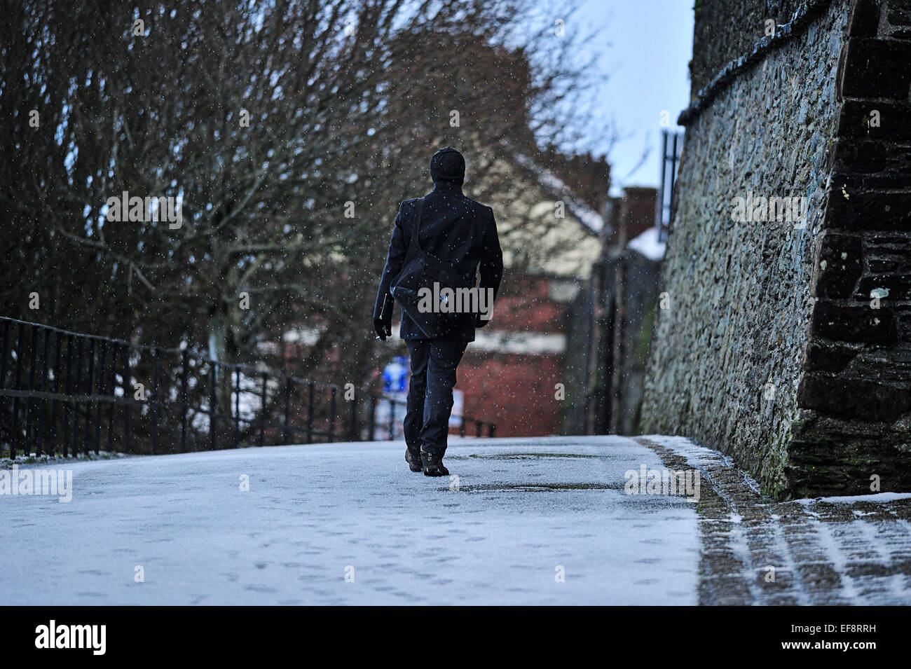 Londonderry, Northern Ireland. 29th January, 2015. UK weather: Snow in Londonderry.  A man walks across a snow covered path in Londonderry (Derry) in Northern Ireland. More snow is forecast for many parts of Northern Ireland and Britain tomorrow Credit:  George Sweeney/Alamy Live News Stock Photo