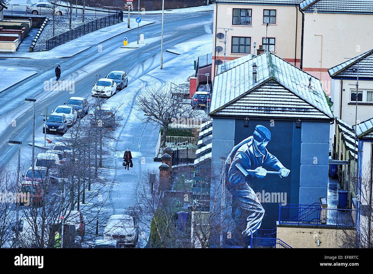 Londonderry, Northern Ireland. 29th January, 2015. UK weather Snow in Londonderry A woman with a pram walks past a mural in Londonderry (Derry) in Northern Ireland. More snow is forecast for many parts of Northern Ireland and Britain tomorrow Credit:  George Sweeney/Alamy Live News Stock Photo