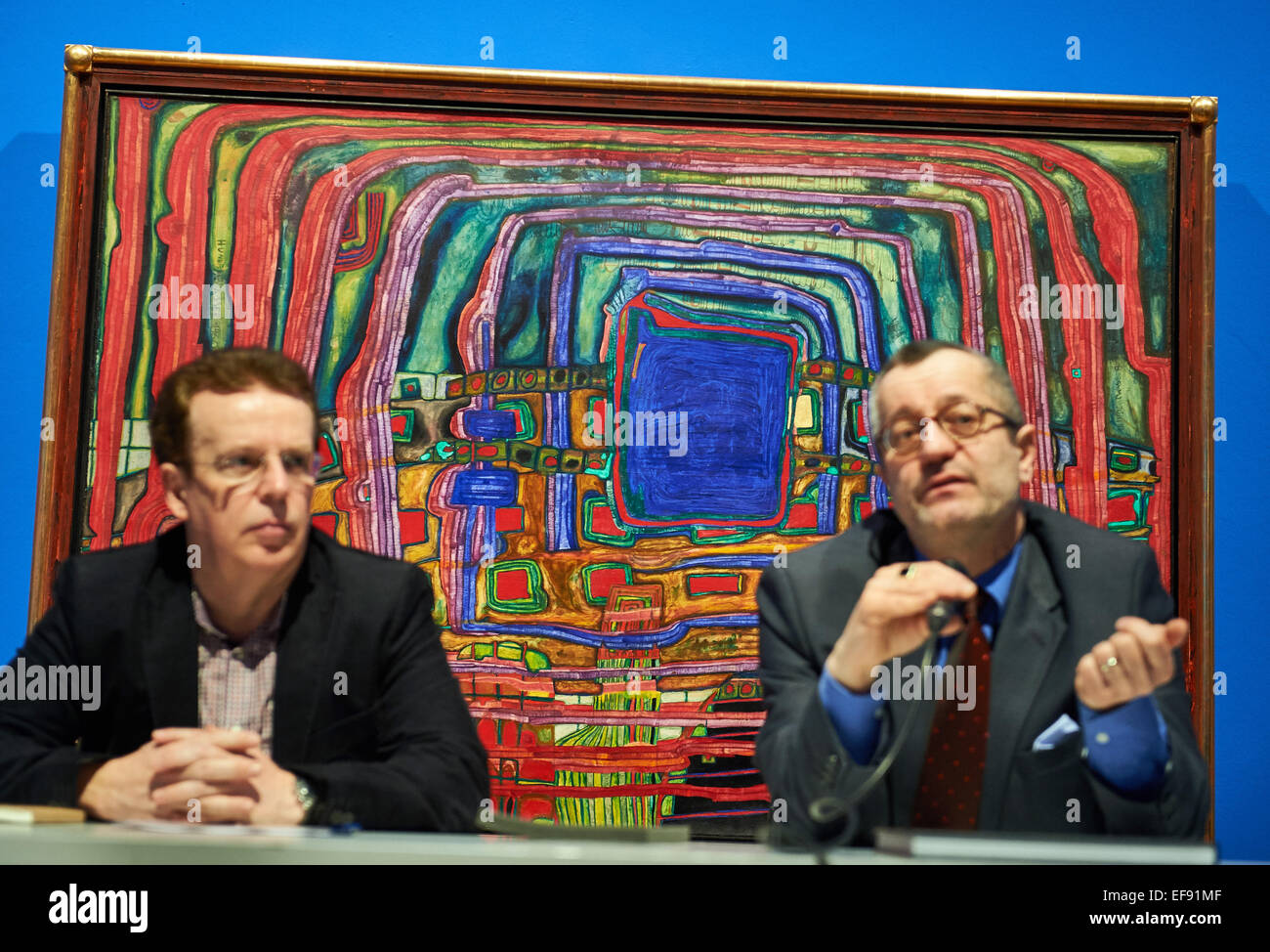 Museum director Tayfun Belgin and his assistant Dietmar Freiesleben (L) speak during a press conference while sitting in front of the painting 'Le je nesais pas encore' at the Osthaus Museum in Hagen, Germany, 29 January 2015. The exhibition 'Hundertwasser Lebenslinien' presents 130 paintings by Friedenreich Hundertwasser. According to informations by the Museum, the exhibition is the universal artists first comprehensive retrospective in Germany since 17 years. It's open from 1 February until 10 May 2015. PHOTO: BERND THISSEN/dpa Stock Photo