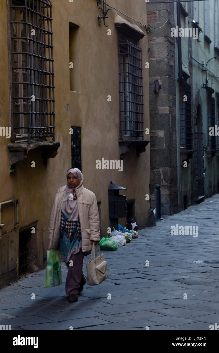 Muslim woman carrying her shopping in the city centre of Lucca, Tuscany, Italy Stock Photo