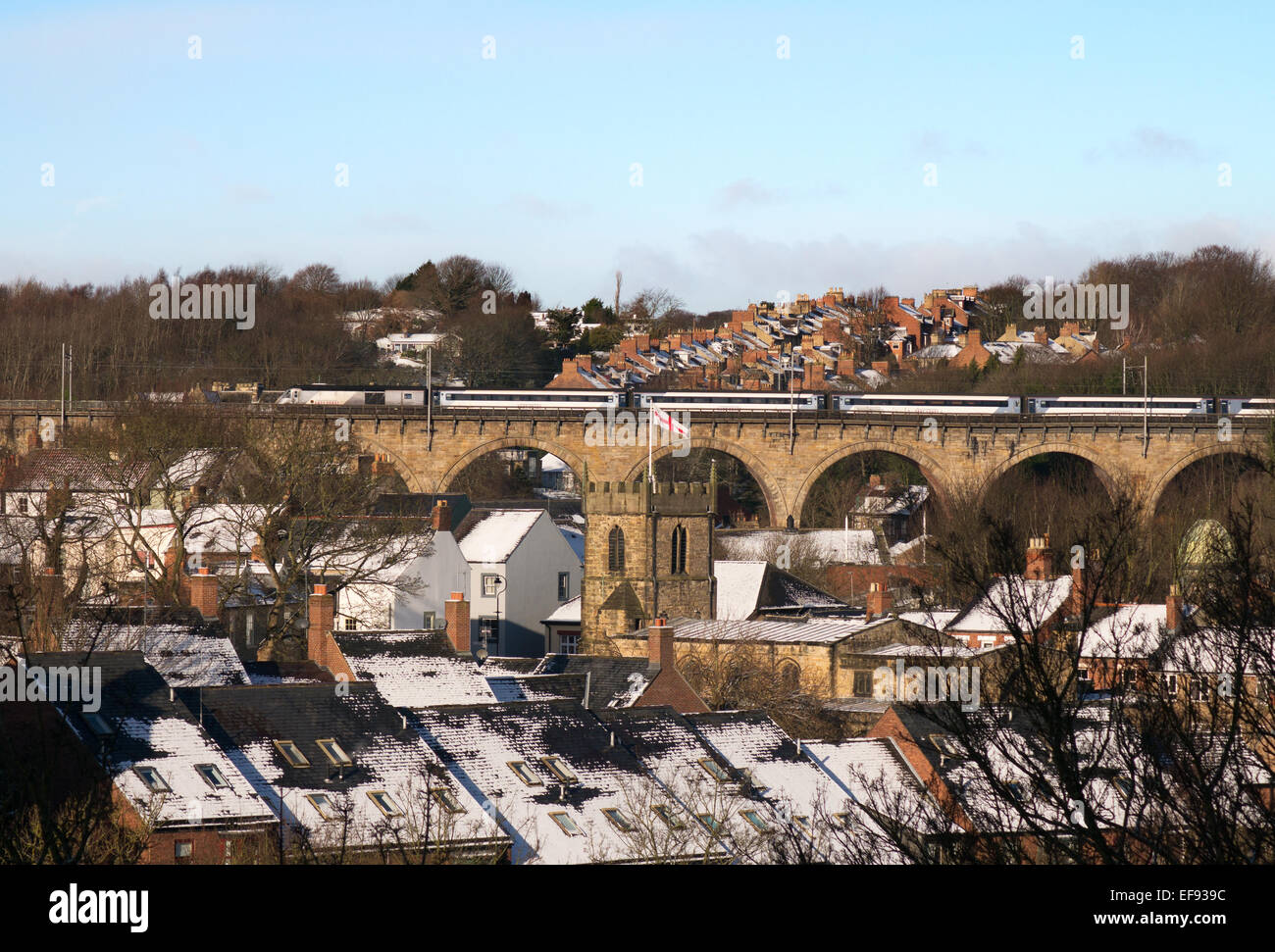 Durham City, UK. 29th Jan. 2015. UK Weather: A sunlit East Coast trains heads south over Durham viaduct with roofs of foreground buildings covered in snow. Credit:  Washington Imaging/Alamy Live News Stock Photo