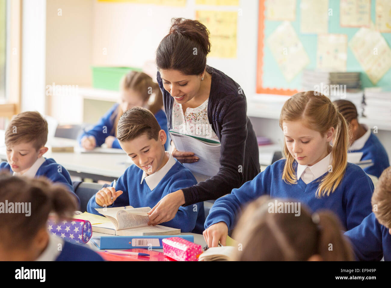 Female teacher with her pupils in classroom Stock Photo