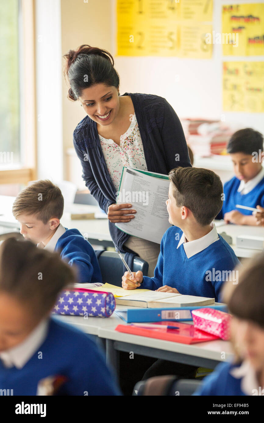 Teacher and elementary school children in classroom during lesson Stock Photo