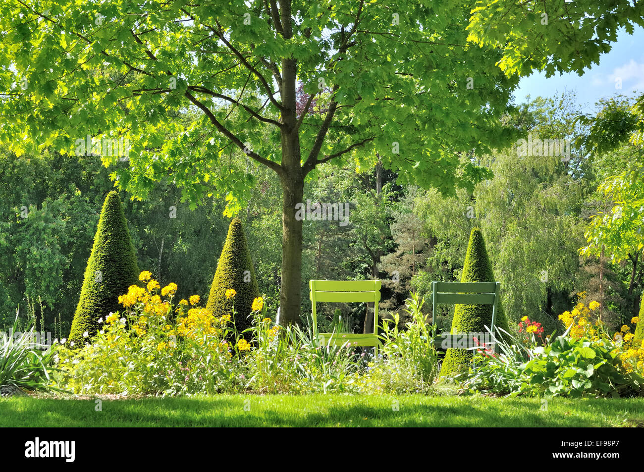 chairs in a beautiful green landscaped garden Stock Photo