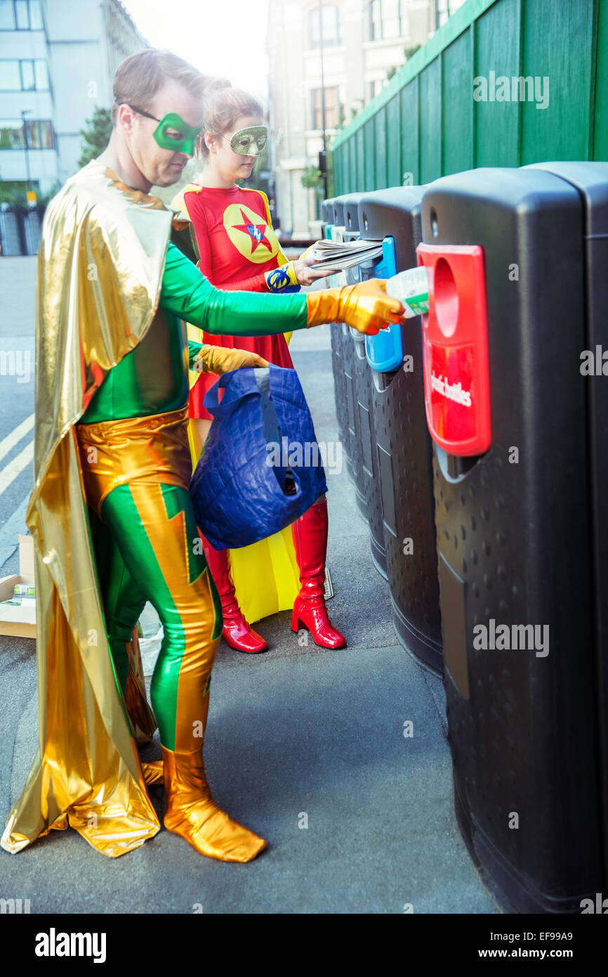 Superhero couple recycling on city sidewalk Stock Photo