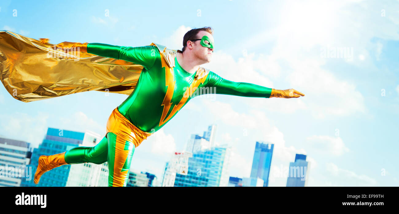 Superhero flying on city rooftop Stock Photo