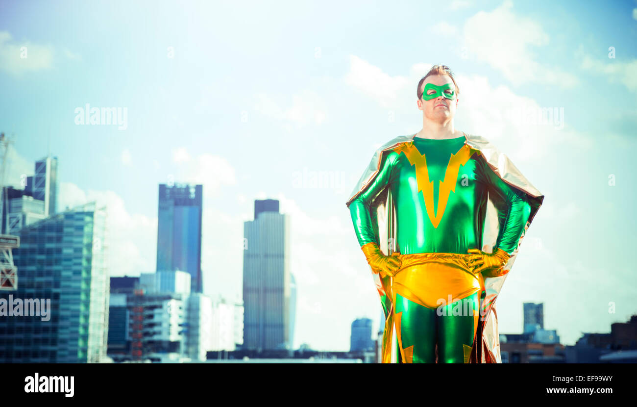 Superhero standing near city skyline Stock Photo