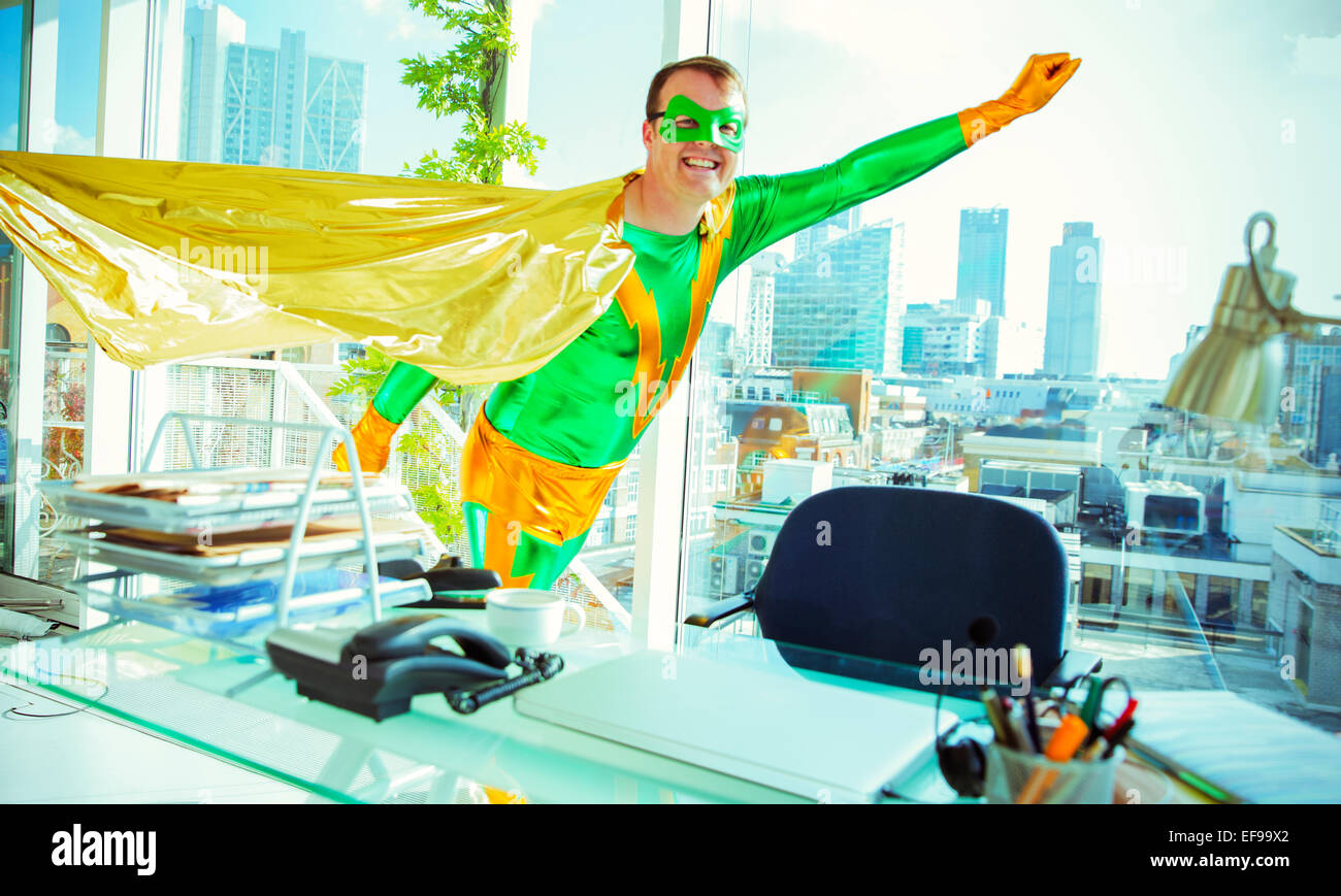 Superhero flying in office Stock Photo