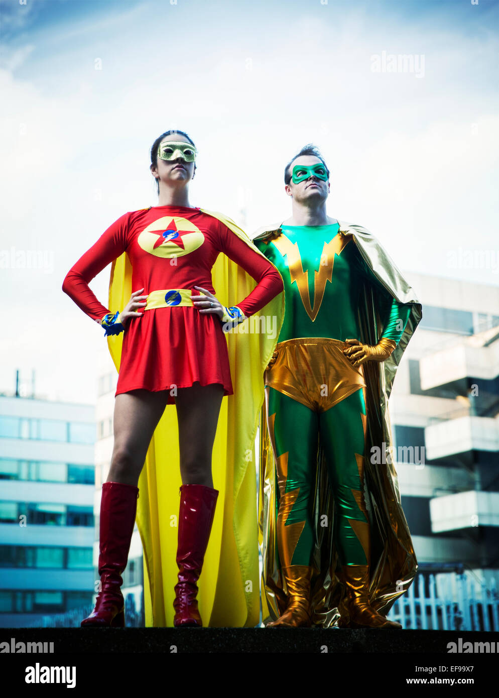 Superheroes standing on city rooftop Stock Photo
