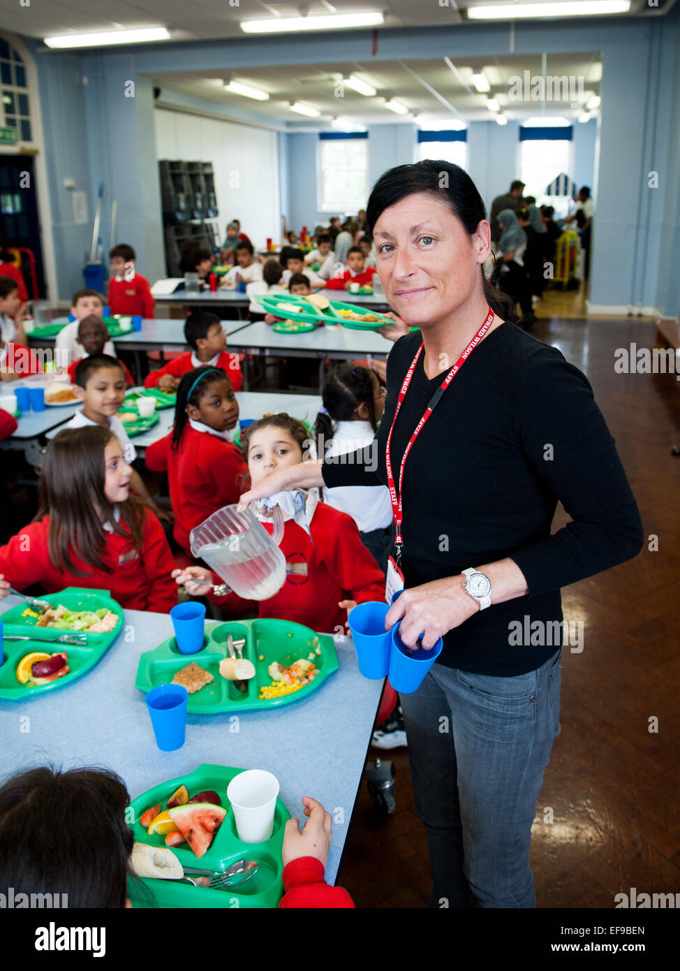 Lunchtime at UK State Primary School  Dinner lady serving Primary school children at  Primary School Stock Photo