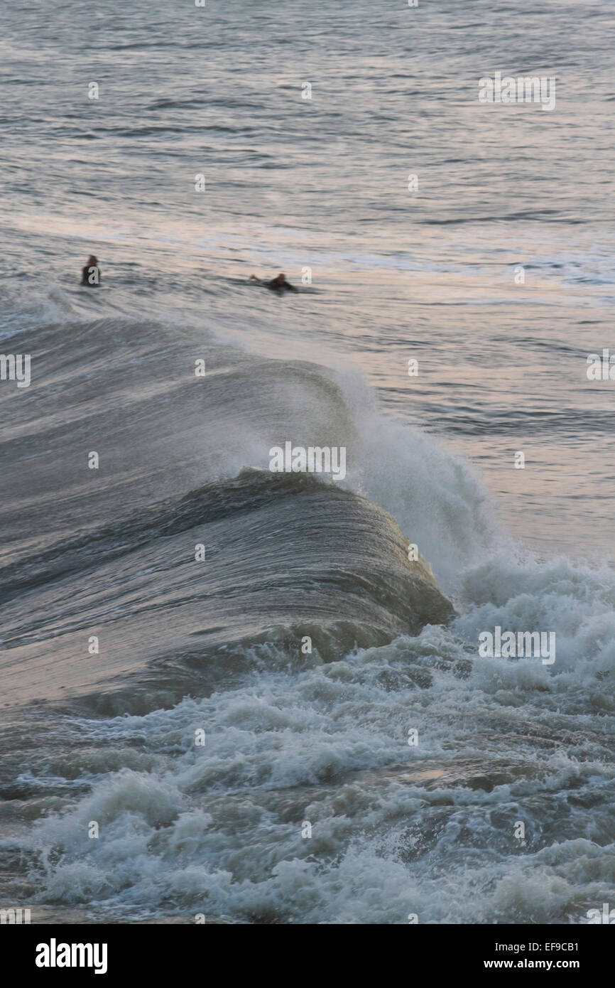 Seen from above, surfers watch but don't try to catch some large ocean waves off of Hurricane Sandy Stock Photo