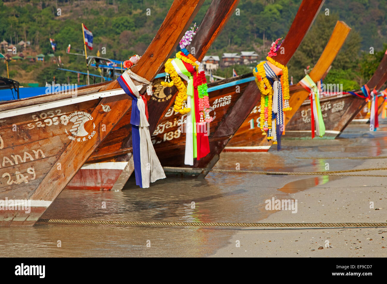 Prows of traditional wooden fishing boats on beach of one of the Ko Phi Phi islands, Southern Thailand Stock Photo