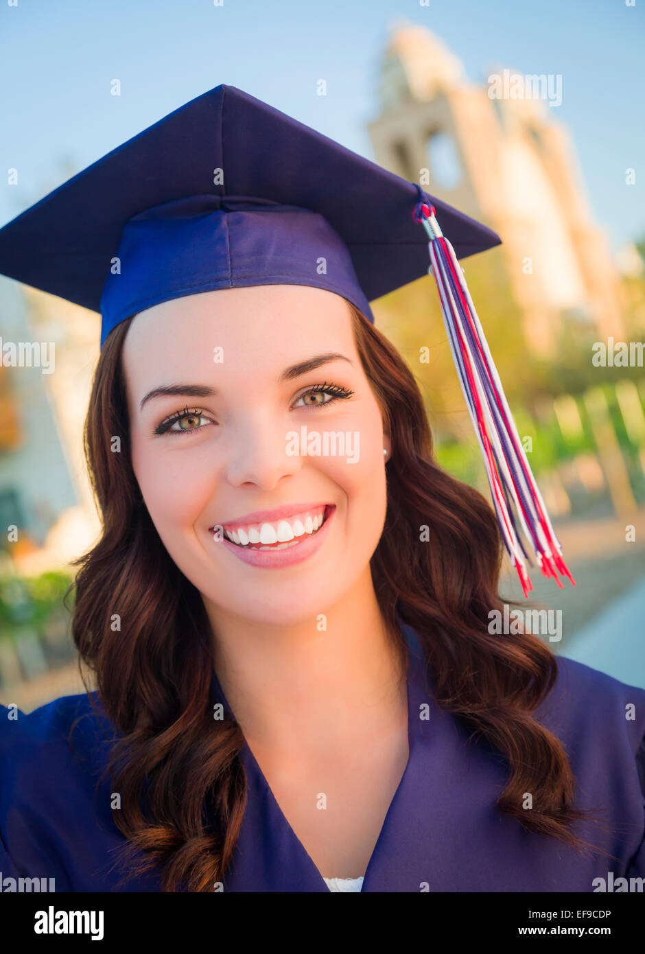 Happy Graduating Mixed Race Woman In Cap and Gown Celebrating on Campus