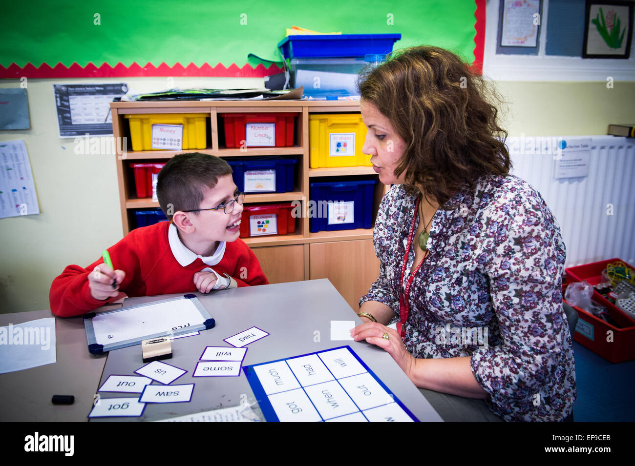 Learning support assistant (LSA) with Special Educational Needs and Disability (SEND)child in literacy class  Primary School, Paddington London W2 Stock Photo