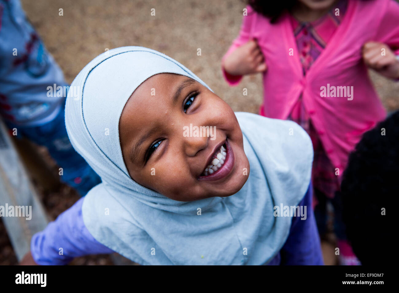 Happy Smiling muslim girl in headscarf in the playground of Primary school in London W2 Stock Photo
