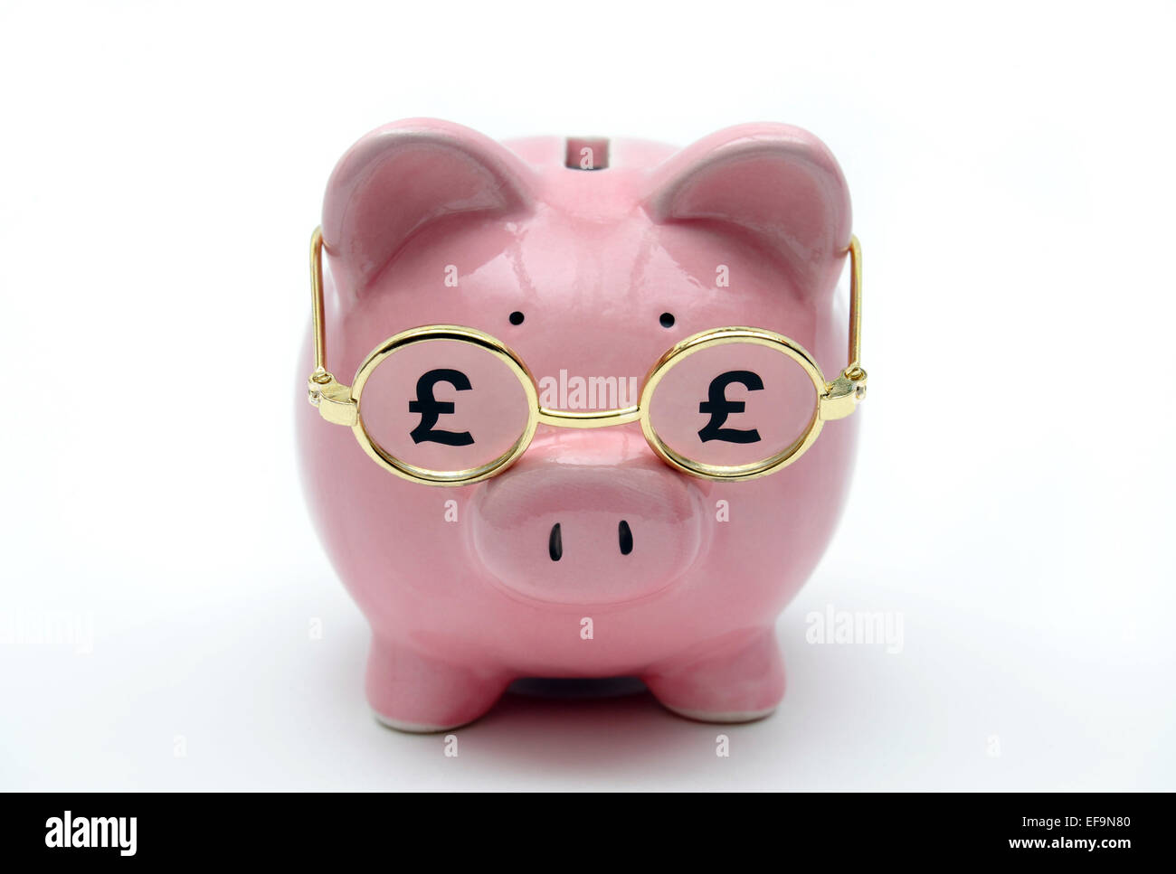 PIGGY BANK WEARING GLASSES WITH POUND SIGNS RE PENSIONS PENSION SCHEME SAVINGS RETIREMENT NESTEGG COMPANY PRIVATE INCOME CASH UK Stock Photo