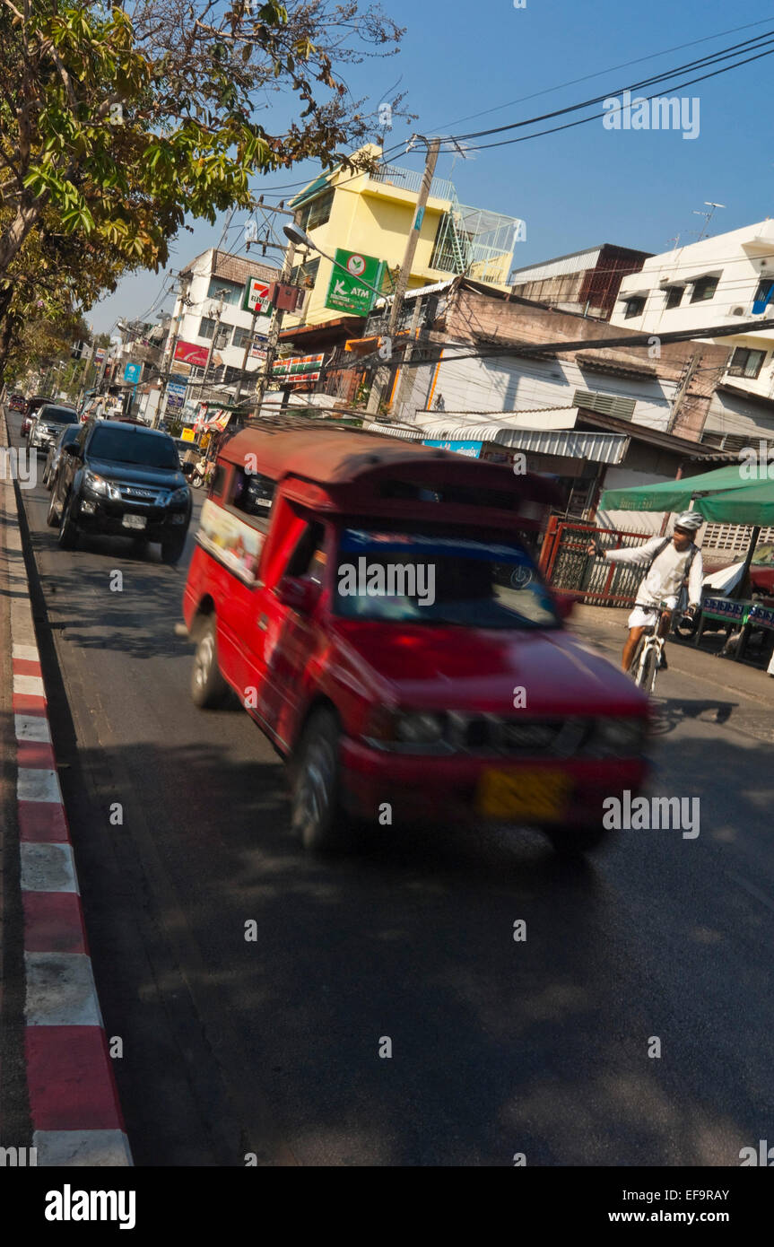 Vertical streetscape with a Songthaew (baht bus) driving by in Chiang Mai. Stock Photo