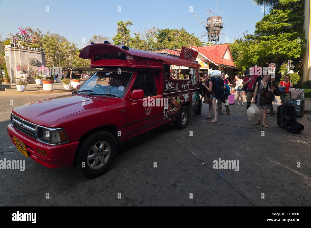 Horizontal view of a tourists getting off a tuk-tuk in Chiang Mai. Stock Photo