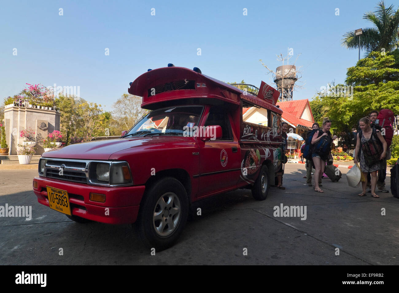 Horizontal view of a tourists getting off a tuk-tuk in Chiang Mai. Stock Photo