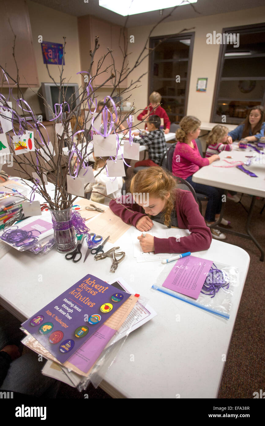 Children at St. Timothy's Catholic Church, Laguna Niguel, CA, make a Jesse tree which symbolizes the time of preparation for the celebration of the Nativity of Jesus at Christmas. Note art supplies on table and instruction book. Stock Photo