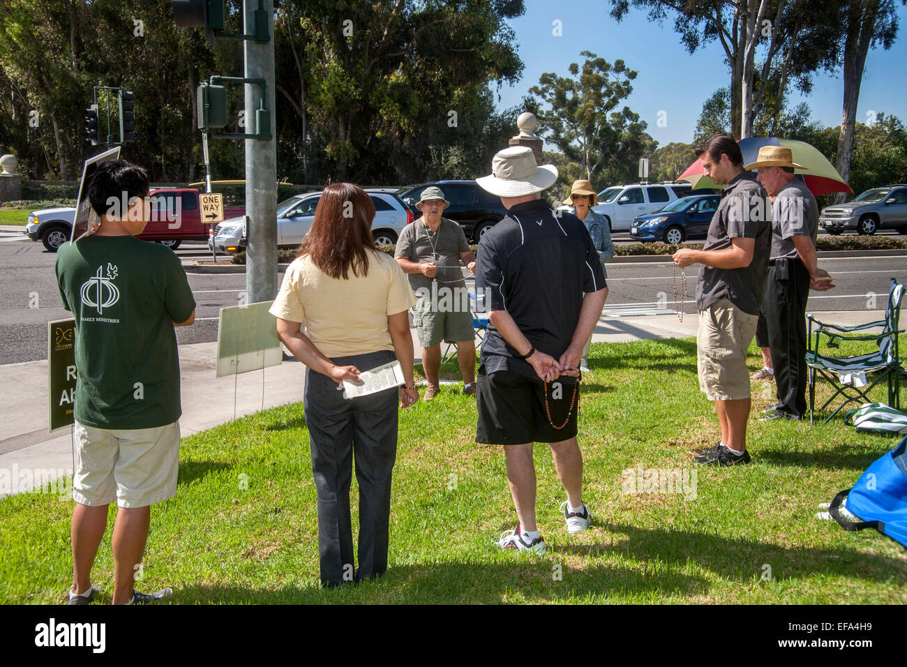 Catholics opposed to abortion attend a prolife vigil on a street corner in Mission Viejo, CA. Note rosary. Stock Photo