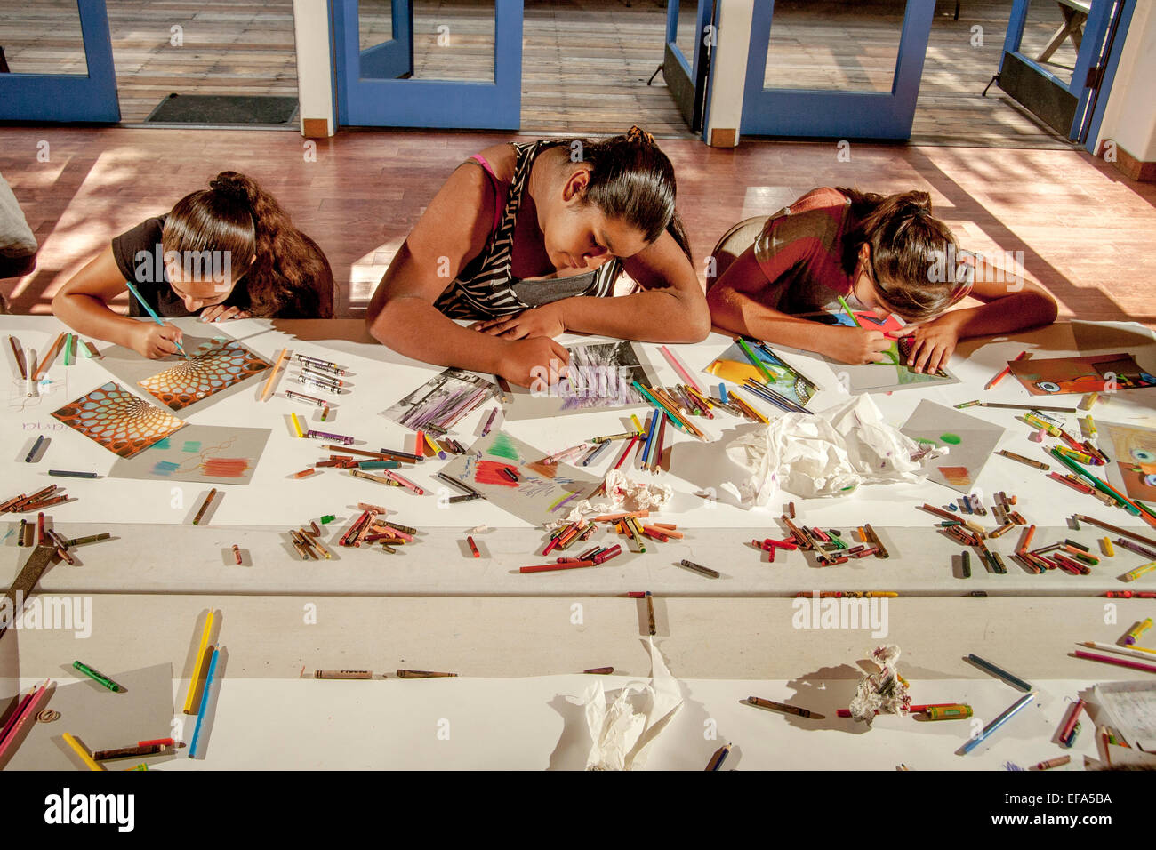 A middle school Hispanic teen girl work on her picture at a free