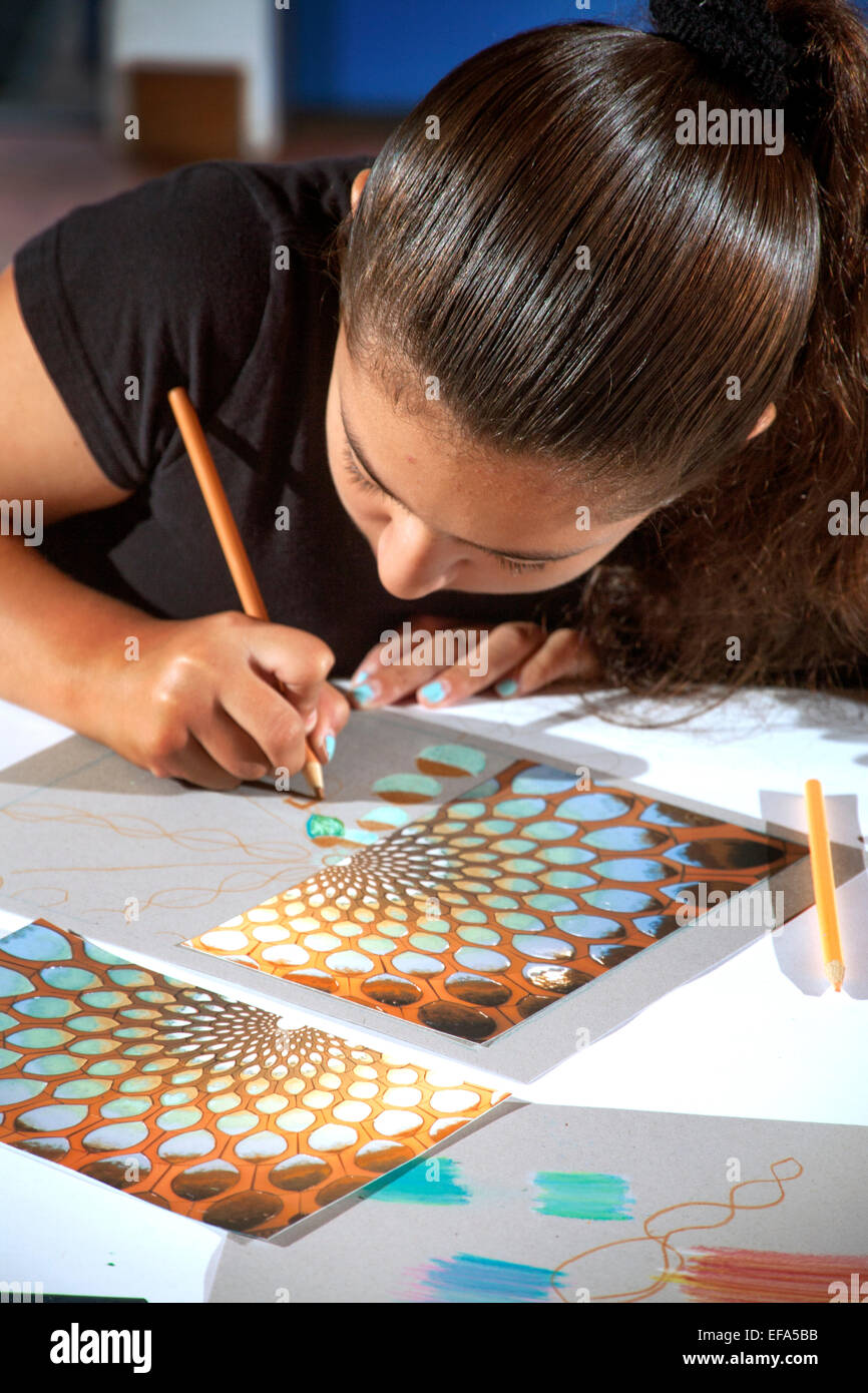 A middle school Hispanic teen girl work on her picture at a free