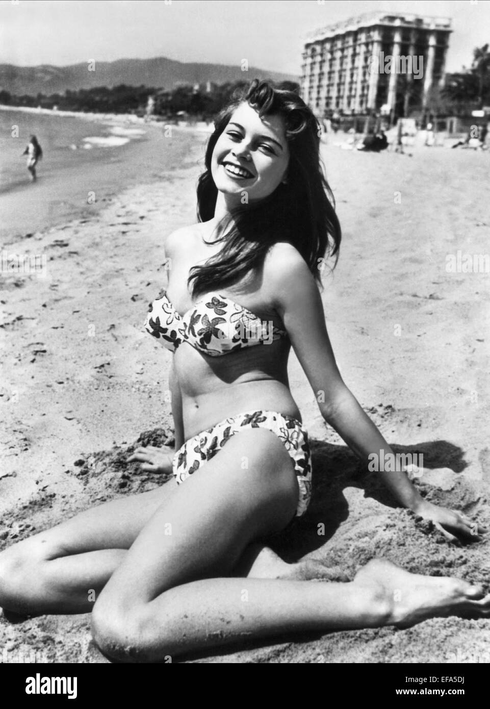 Med hennes kropp og  hårtype uten BH (BH-størrelse 36B) på stranda i bikini
