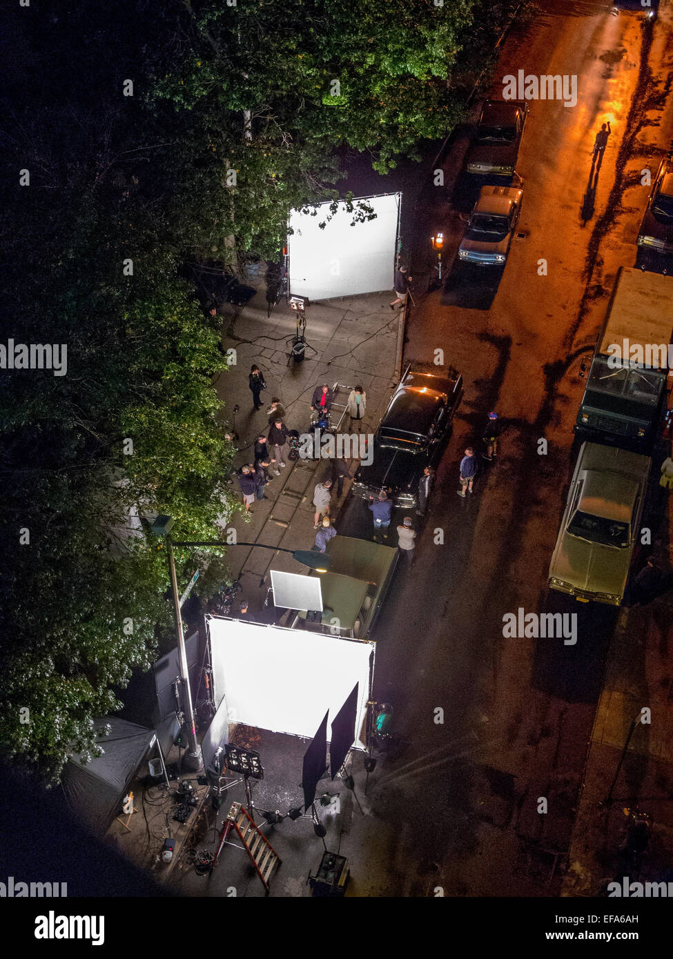 A location film crew works by night on a Manhattan street in New York City. Note large diffusers for lights and track for camera. Stock Photo