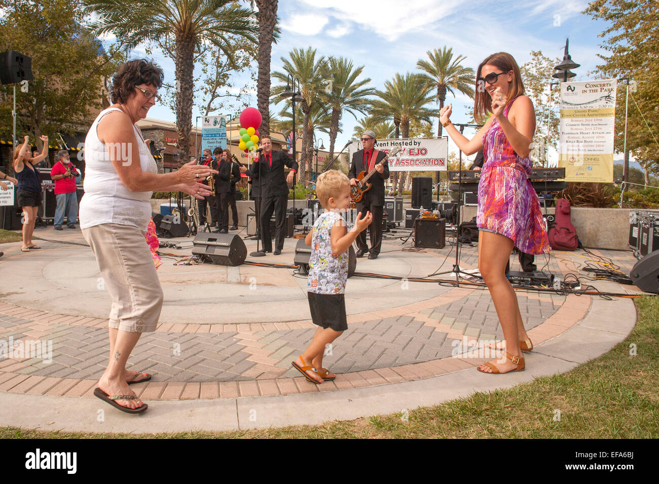 Three generations of a family dance to a live band at an evening