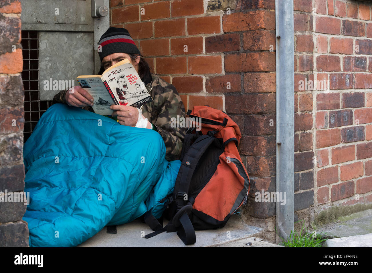 A homeless man reading a book while in his sleeping bag Stock Photo - Alamy