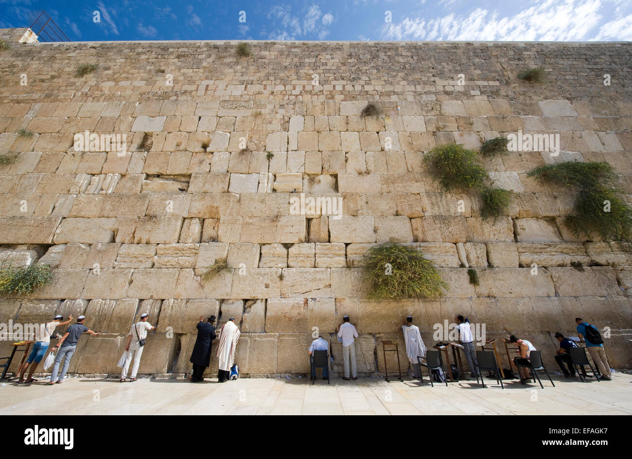 Jewish men are praying in front of the western wall in the old city of Jerusalem Stock Photo