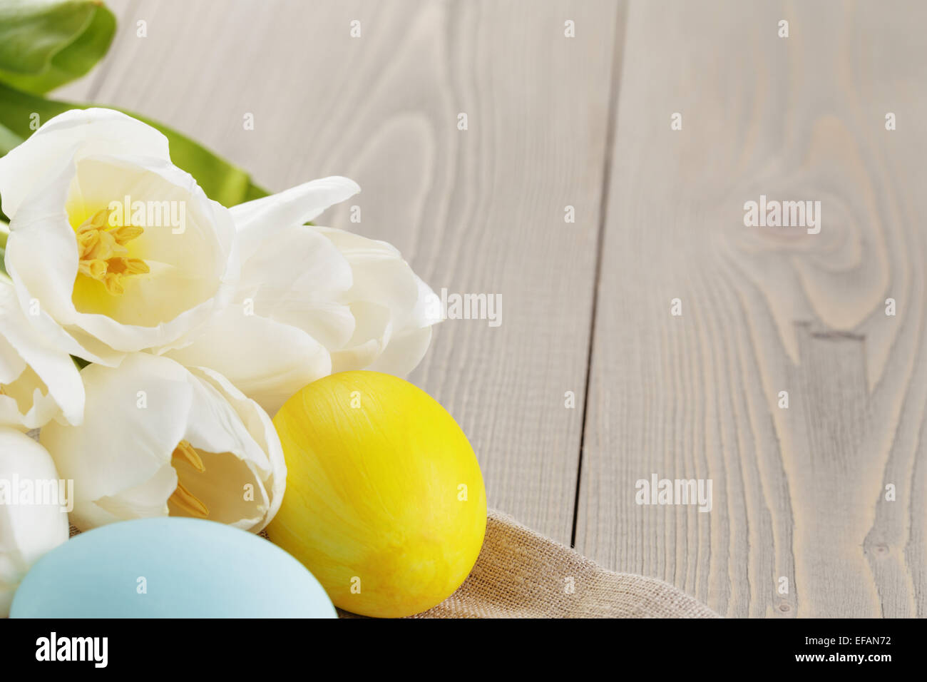 easter eggs and white tulips on wood table Stock Photo - Alamy
