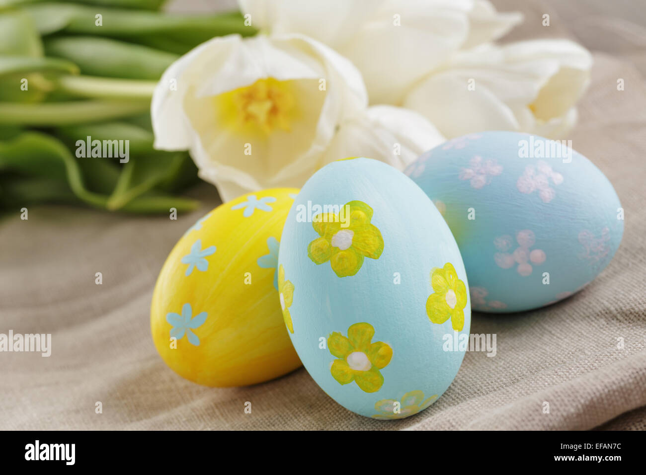 handpainted easter eggs and white tulips on wood table Stock Photo - Alamy