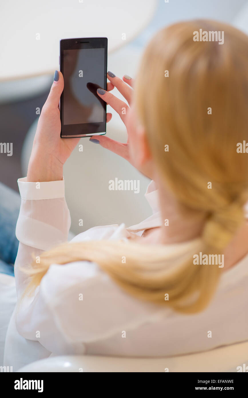 Rear View of Blond Woman Using her Smart Phone Stock Photo - Alamy