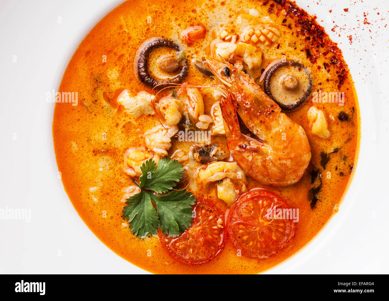 Spicy Thai soup Tom Yam with Chili pepper and Seafood close up Stock Photo