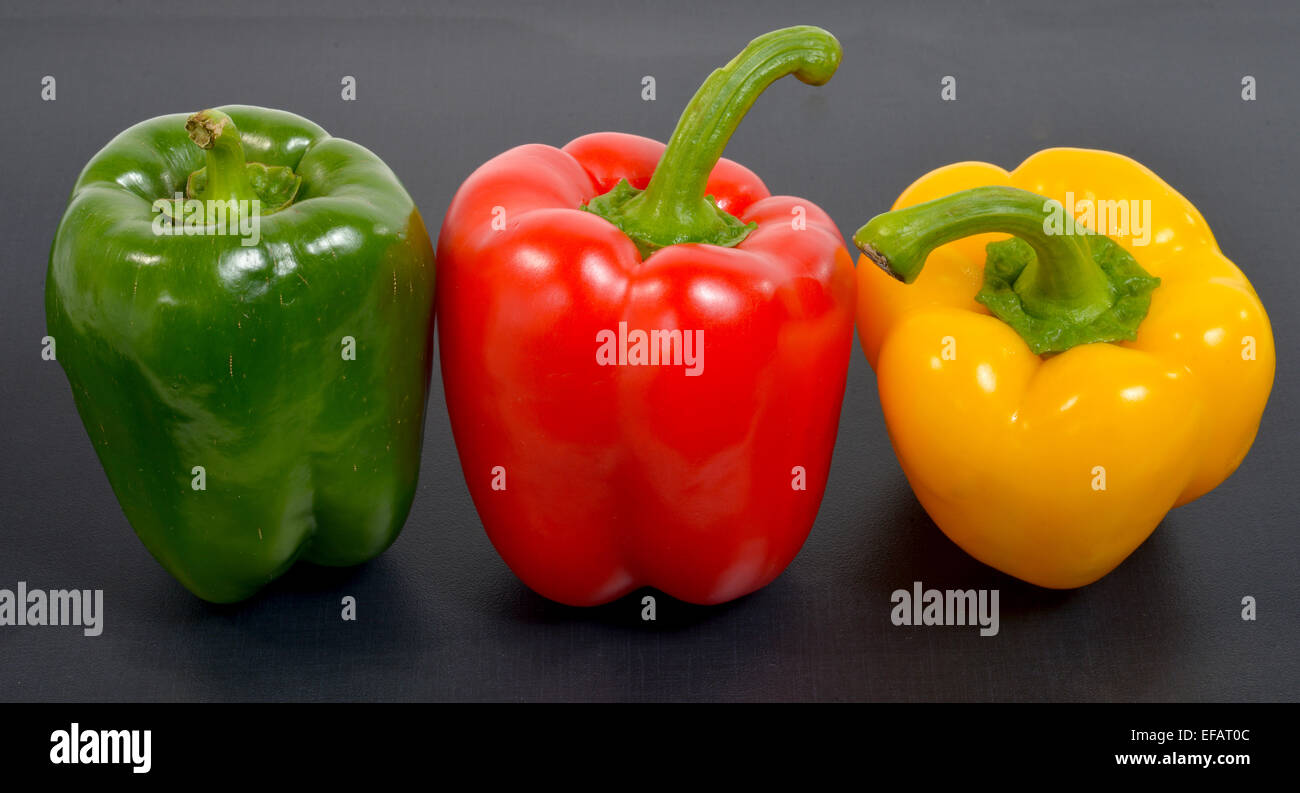 three peppers isolated on a black table Stock Photo - Alamy