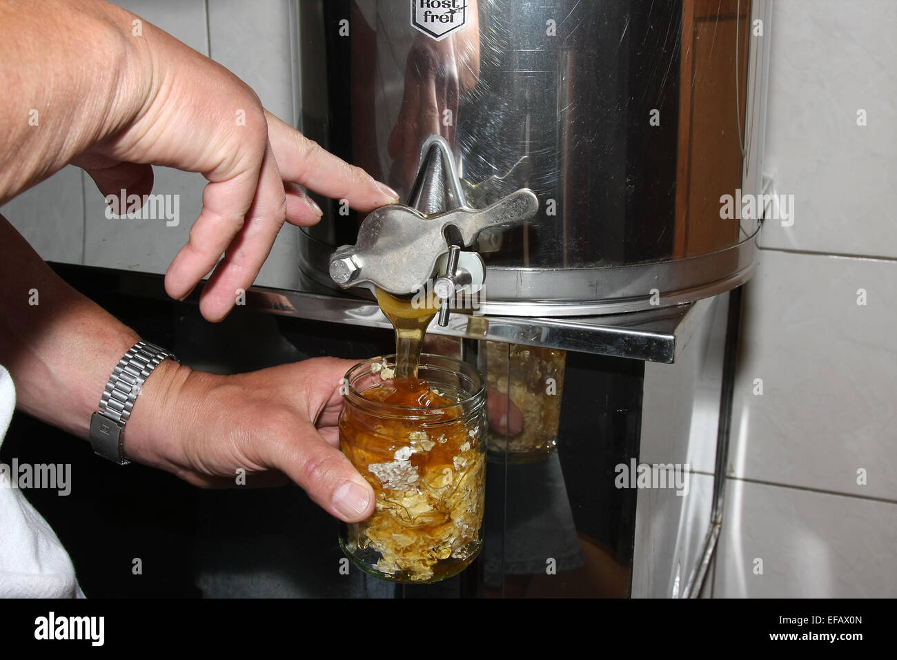 Finally, the glass with chewing wax is filled with honey. Chewing wax is obtained during the honey harvesting by the uncapping of ripe honeycombs. Photo: Klaus Nowottnick Date: June 19, 2011 Stock Photo