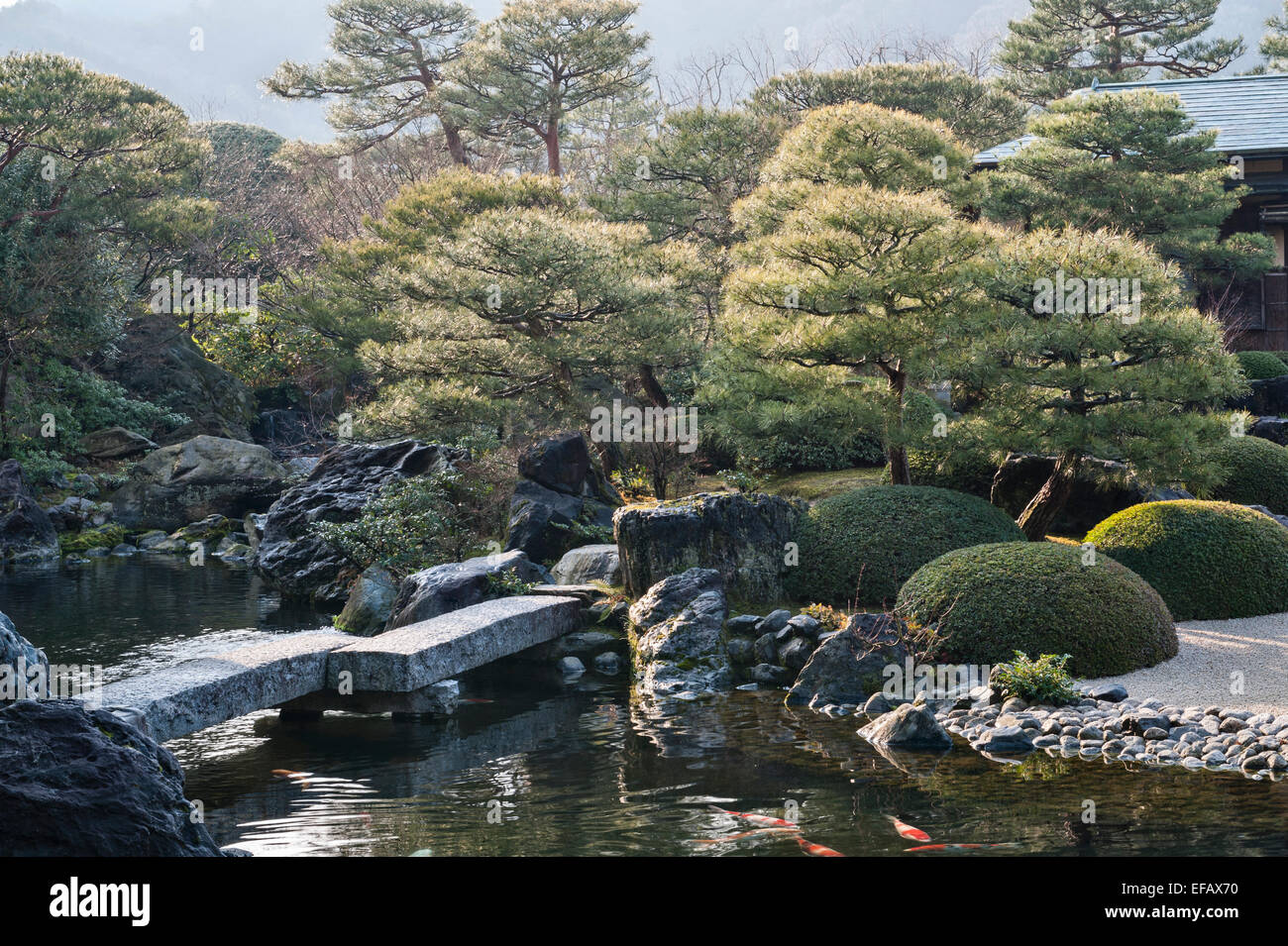 Matsue, Honshu, Japan. A stone bridge in the Pond Garden in the 20c gardens of the Adachi Museum of Art, made by Adachi Zenko in 1970 Stock Photo