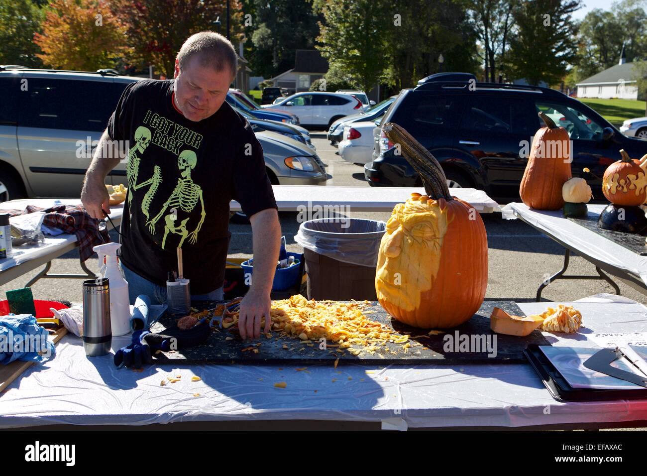 Man working on carving a pumpkin Stock Photo