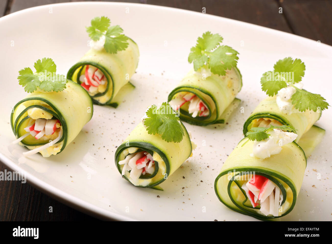 Cucumber wrapped with mashed eggs and surimi Stock Photo