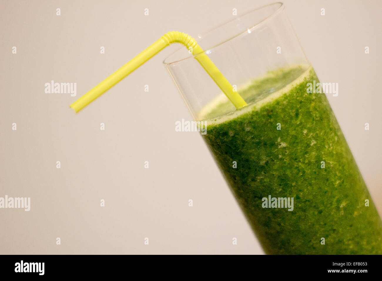 Green smoothie shot at an angle with light green straw Stock Photo