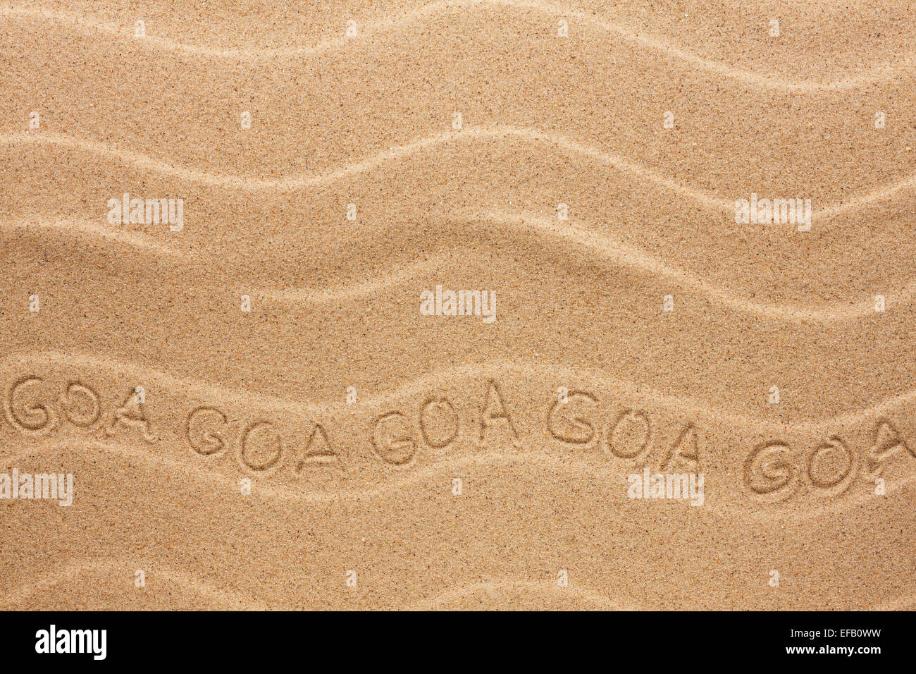 Goa inscription on the wavy sand, as background Stock Photo