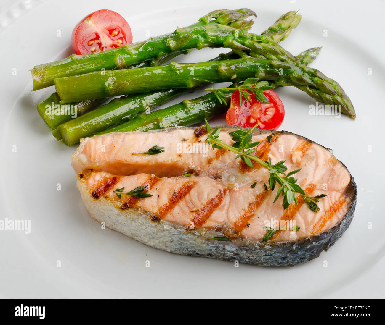 Grilled salmon with green asparagus   on a white plate. Selective focus Stock Photo