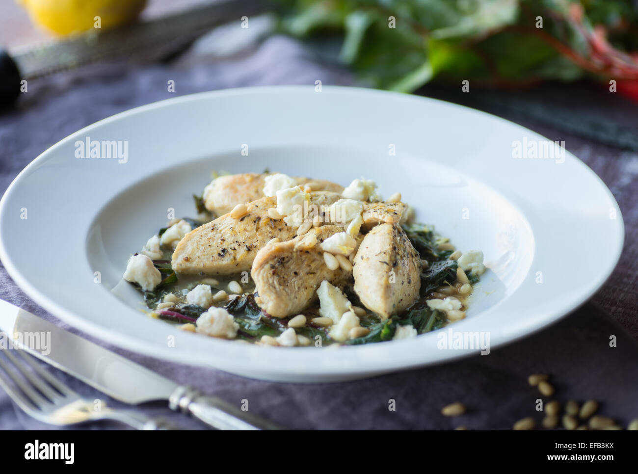 Lemon Chicken with Sauteed Chard and Pine Nuts Stock Photo